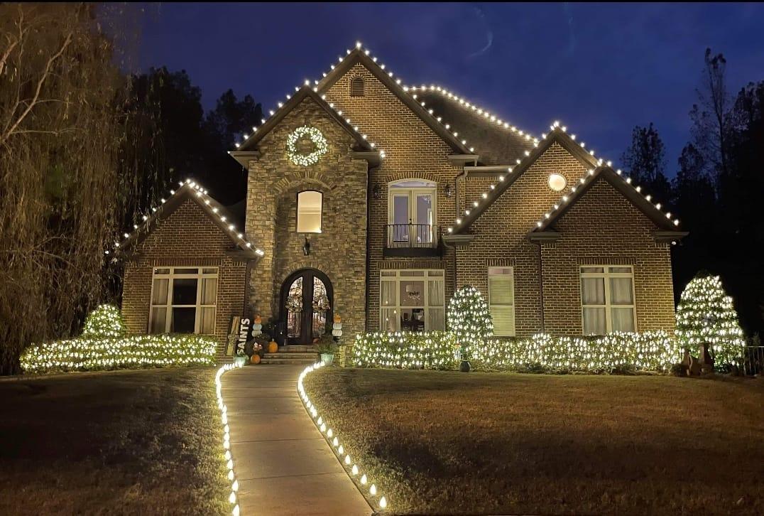 Two story brick home with every roof line, walkway and shrub outlined in warm white bulbs